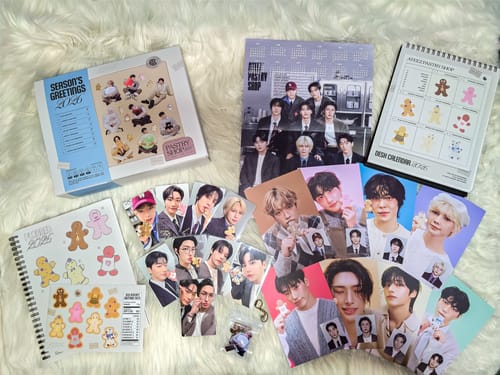 Reviewer displaying all contents of the ATEEZ 2026 SEASON'S GREETINGS set, including calendars, photocards, and posters.