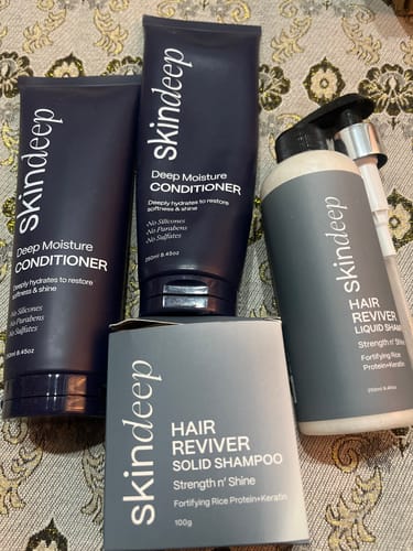 Reviewer's collection of Skindeep products, including the Hair Reviver Solid Shampoo box, two conditioners, and a liquid shampoo.