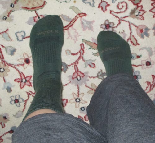 Reviewer's view of their comfy Harbor Crew Socks in forest green worn indoors.