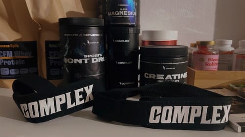 Customer's Ultimate Performance Bundle products, including Creatine and Iont Drink, shown with branded lifting straps on a shelf.