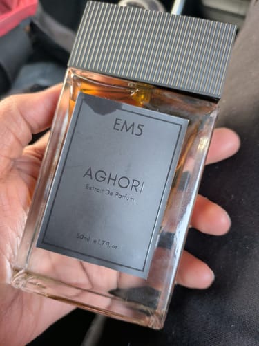 Customer holding the square glass bottle of Aghori Extrait De Parfum in their hand.