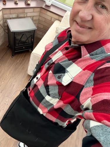 Close-up: Reviewer wearing the black ALTA bag across their body while smiling.