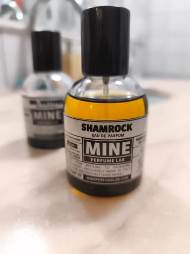 Primo piano del flacone di profumo SHAMROCK del recensore, che mostra il liquido dorato all'interno.