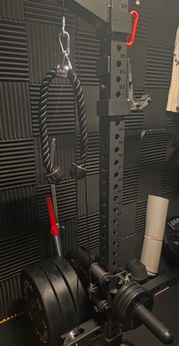 Kunde zeigt das R7 Plate Loaded Cable System, montiert an einem Rack und beladen mit Gewichten und einem Seil.