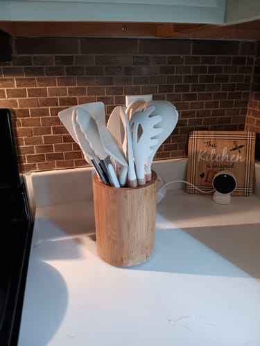 Customer's white Silicone Utensils Set with wooden handles in a matching holder on a kitchen counter.