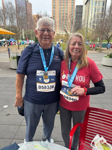 Two happy reviewers posing with their finisher medals after a race.