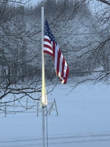 Customer's Ultra Heavy Duty American Flag hanging from a flagpole in a snowy winter scene.