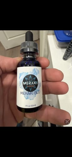 Customer holding the Meraki Blu Methylene Blue bottle in their hand.