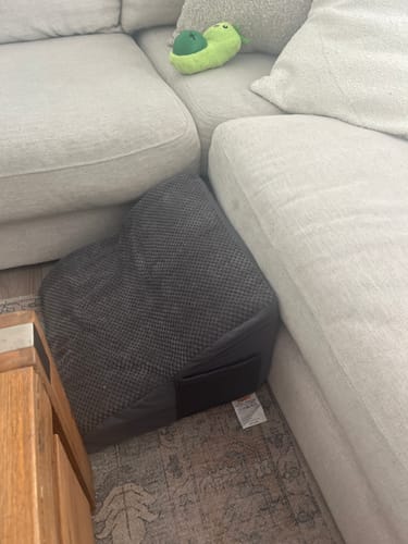 Customer's grey 2-step foam pet steps placed neatly in the corner of a sectional sofa.