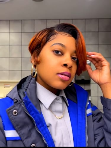 Reviewer wearing the short Swoop 12 wig with dark roots and coppery bangs. The wig is styled in a deep side swoop.