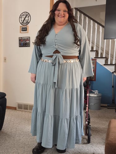 Reviewer in a full-length photo wearing the long, dark Sensationnel Clip-In Weave blended into their hair.