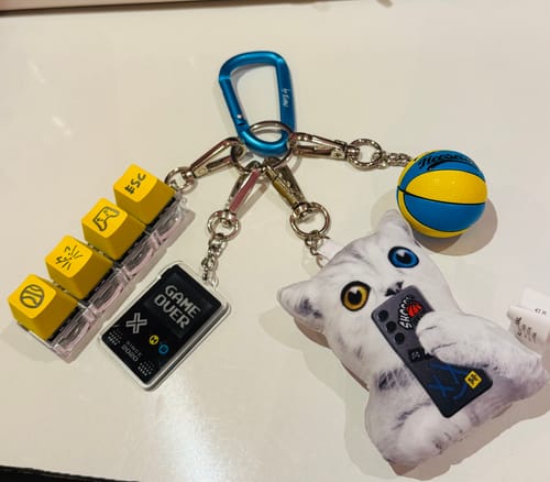 Customer's Evan's Unserious Keyring Package displayed with all its charms, including the yellow keyboard keys and plush cat.