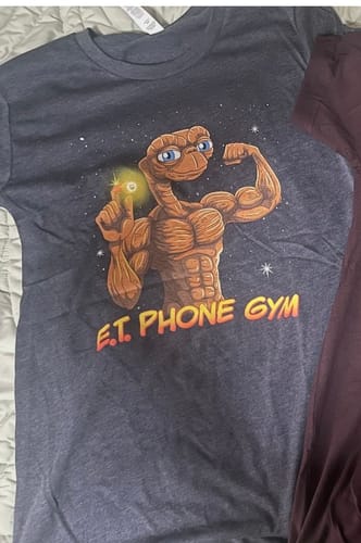 Customer's dark grey E.T. Phone Gym T-Shirt laid out, showing the muscular E.T. graphic.