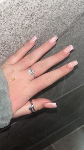 Close-up of a customer's hand wearing the silver Hug Ring on their thumb.