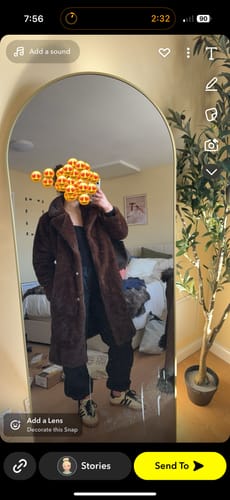 Reviewer showing the fit of the long, brown Lucie Faux Fur Maxi Coat in a mirror selfie.
