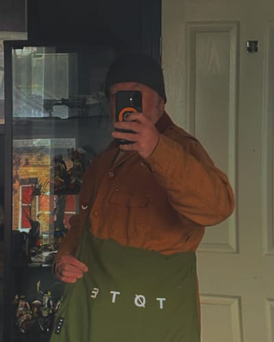 Reviewer taking a mirror selfie while holding their Khaki Green TØTE Bag.