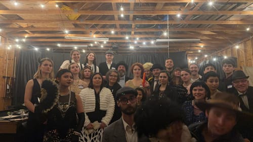 Reviewer's photo of a large group in 1920s costumes playing the Murder Mystery Game Kit.