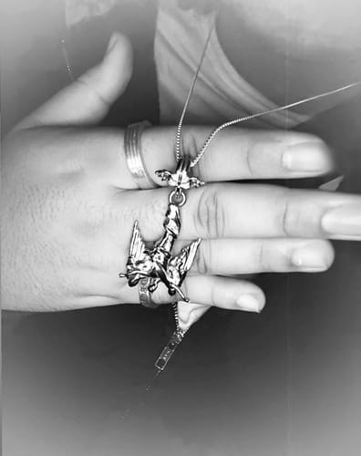 Close-up of a customer holding the 1.4mm Sterling Silver Box Chain with a detailed pendant against their hand.