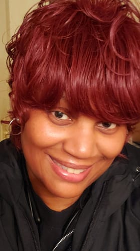 Close-up of a customer wearing the wavy, reddish Chade Fashion Cutie Too Full Wig.