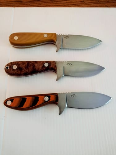 Reviewer's three custom knives with different hardwood handles finished using the sanding belts.