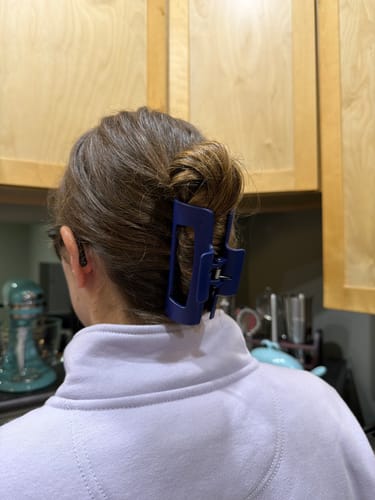 Reviewer from behind showing a blue cloud clip holding their brown hair in a bun.