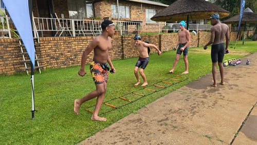 Reviewer's swimmers using ProPulse® Speed Trainers during a dry-land agility ladder exercise.