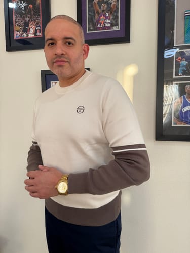 Close-up of a reviewer wearing the Giovane Crewneck, showing the Gardenia top and brown color-blocked sleeves.