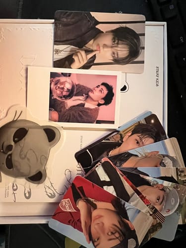Customer's Stray Kids SKZOO album unboxed, showing the Jiniret speaker and several photocards.