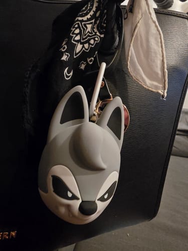 Reviewer's cute SKZOO speaker attached to a black handbag with a bandana.