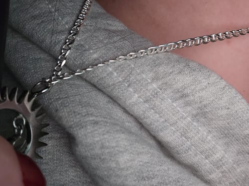 Close-up of a reviewer wearing the 3mm Sterling Silver Mariner Chain around their neck over a grey top.