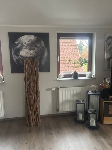 Rezensent zeigt die Teak Wurzelholz Stehlampe im Wohnzimmer, aufgestellt auf einem Holzboden neben einem Fenster.