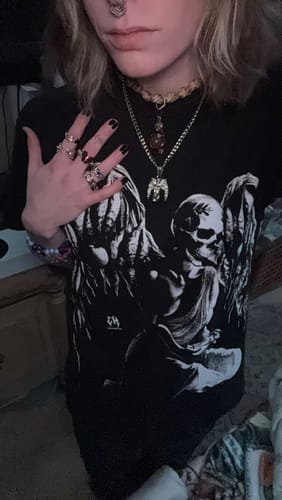 Reviewer wearing the silver Virgo Zodiac Pendant on a chain, layered with other necklaces against a dark shirt.
