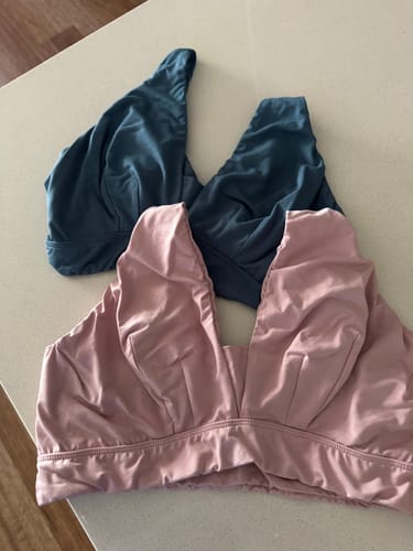 Customer's two Adele Bralettes, one pink and one teal, laid out on a counter.