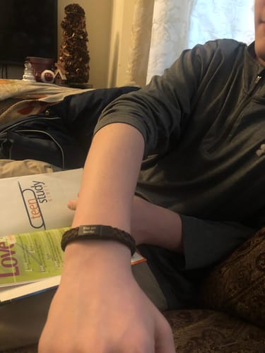Customer wearing the braided brown leather bracelet on their wrist, highlighting the dark clasp.