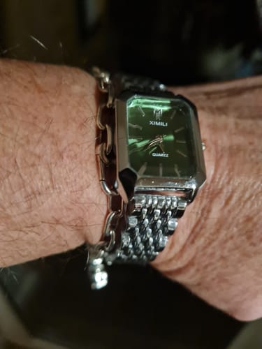 Customer wearing the CLAIRE DE MAINS watch with a rectangular green dial and a silver-toned link band.