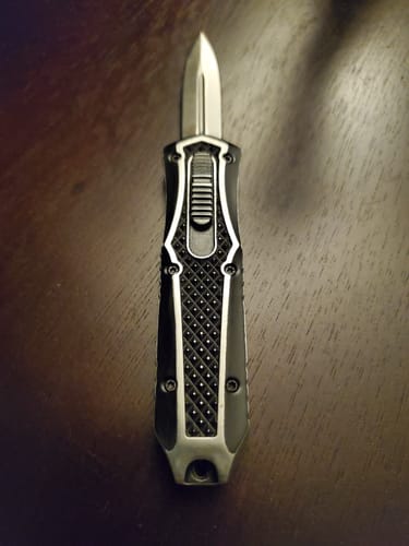 Customer's VT Mini Missile OTF with blade extended, showing the custom-sanded black and silver handle on a wooden table.