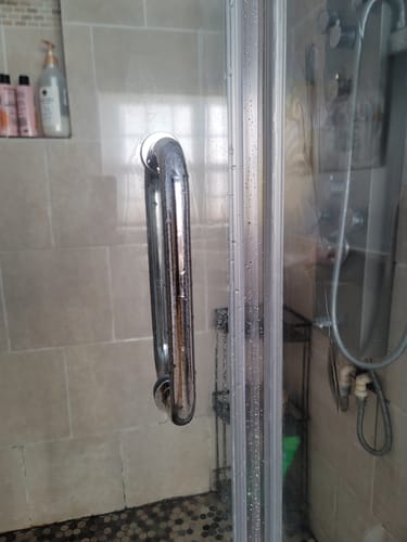 Customer's clean glass shower door after using the Bathroom Bundle to remove hard water stains.