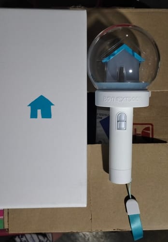 Customer's BOYNEXTDOOR official light stick with a house inside the globe, shown next to its box.