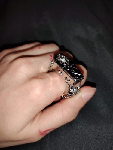 Customer's hand wearing the detailed, silver Fallen Angel Coffin Ring.