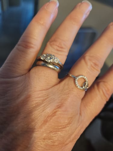Customer's hand showing a delicate ring with a sparkling circle design on the pinky finger.