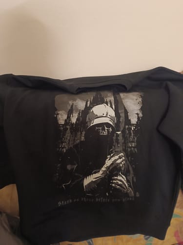 Customer's black oversized organic sweatshirt laid out, showing the detailed graphic print of a skeletal figure on the front.