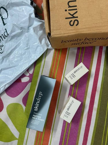 Customer's unboxing of the Peptide Milk Toner, showing the product box next to the shipping mailer and box.