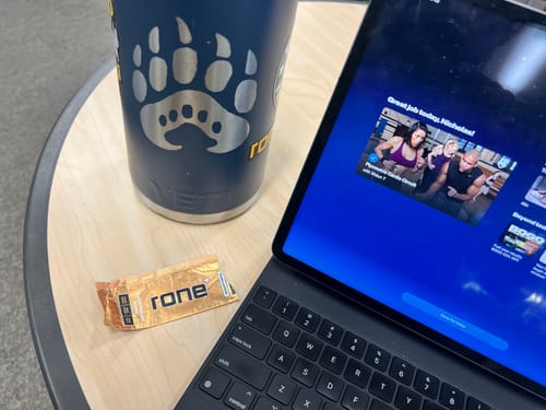 Customer's used SuperCharged Honey packet on a table next to a tablet displaying a post-workout message.