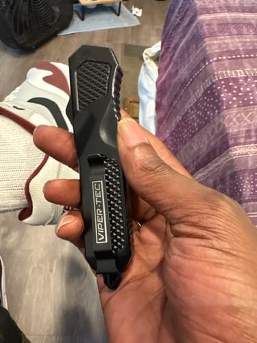 Customer holding the closed Black Phantom D/A OTF knife, showing the textured handle and pocket clip.