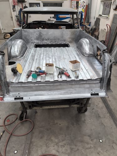 Reviewer's Zirconia Quick Change Discs and tools laid out in a truck bed during an auto restoration project.