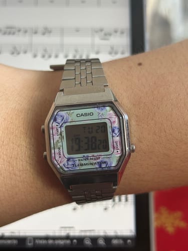 Cliente mostrando su reloj Casio Vintage plateado, con un bonito estampado de flores en la esfera.