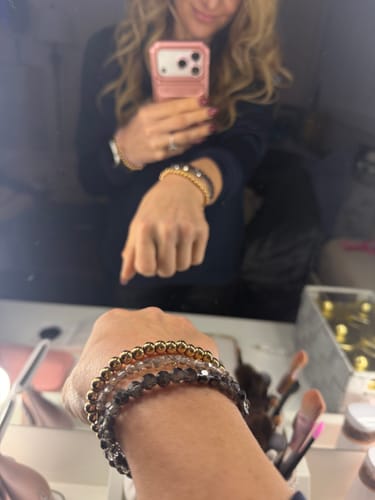 Reviewer's mirror selfie showing a close-up of the stacked Black Diamond Crystal-Accent Bracelet on their wrist.