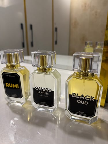 Customer's three perfume bottles from the Winter Box set—Rumi, Ombre Leather, and Black Oud—on a counter.