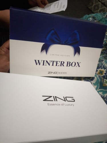 Customer holding the special 'Winter Box' packaging that contains the OUD Supreme BUNDLE.