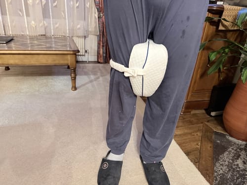 Client portant le coussin pour genoux Cellsius blanc et matelassé, attaché à sa jambe avec la sangle.